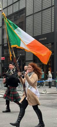 Flagbearer waves to crowd at 264th St. Patrick’s Day Parade on Fifth Ave. on March 17.