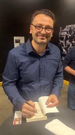 Andy Serra, a retired FDNY captain, signs copies of his historical novel, <i>Hell’s Hundred Acres, </i>at a book launch party staged at the historic Engine 31 firehouse in downtown Manhattan, which is now the DCTV space utilized by community groups and aspiring filmmakers.