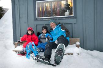 A father and his kids gear up for a guided snowshoe tour at Smugglers’ Notch.