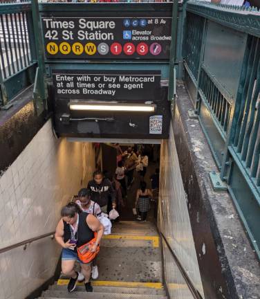 Commuters exit the busy Times Square subway stop at 42nd Street.