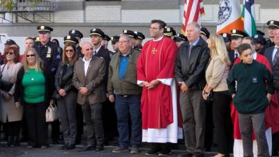 Father Michael Eguino with Buczek and Hoban family members, cops and others.