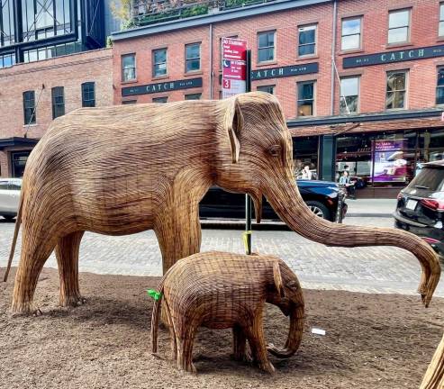 Two of the elephants on display at The Great Elephant Migration in the Meatpacking District. All the elephants are for sale: the elephant baby pictured here is $8,000.00; the money goes towards animal preservation.