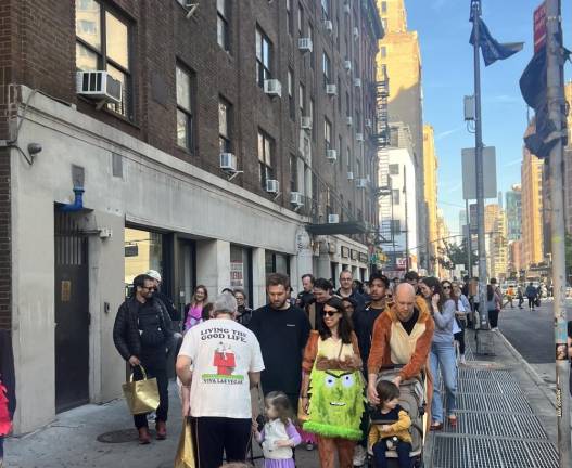 Parents and their colorfully costumed toddlers make their way up 7th Ave. during the annual Buckle My Shoe Halloween parade.