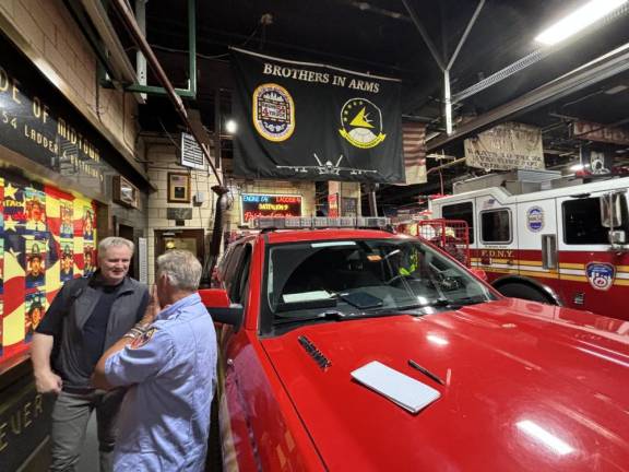 Photographer Peter Foley talks with the current FDNY captain, Robert Hauryluck, at the west side firehouse on W. 48th St. and Eighth Ave. that had the greatest number of fatalities on 9/11. Foley said he rarely ventures back to the house where he lived as a freelance photographer for a year before 9/11.