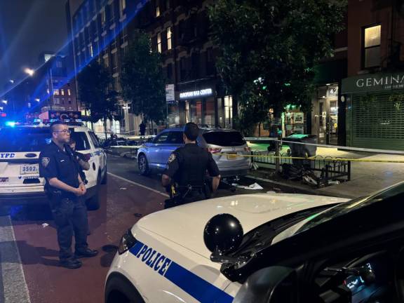 Cops at the scene of the crime on E. 14th on June 23, where one person was killed and two others injured in a knife stabbing rampage by a mentally distubed man. Garbage liters the street. Photo: Keith J. Kelly