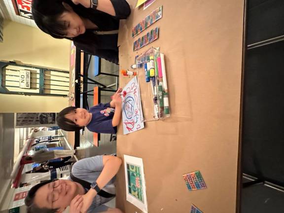 A happy participant has finished his work for the day on July 27. A day of special art making project at Brooklyn’s New York Transit Museum was a resounding success for all ages who spent the afternoon creating transit-focused images on paper.