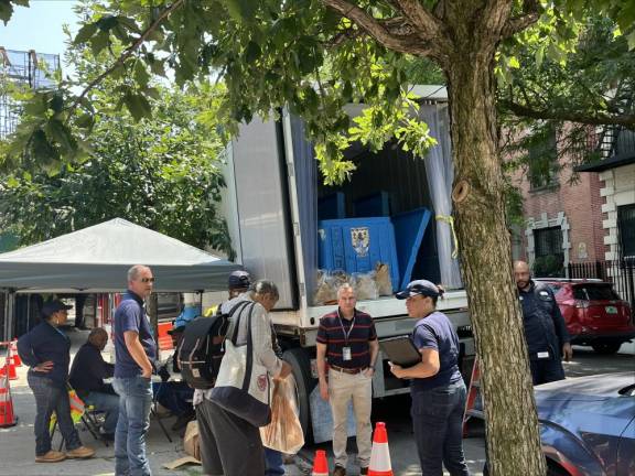 Last week’s heat wave in addition to snarling rail lines, caused power outages across the city. Con Ed workers went about distributing dry ice to Harlem residents experiencing power outages on July 17 to help keep refrigerated food cold.