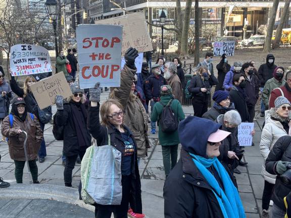 A woman who gave her name as Diana held a sign that read “Stop the Coup.” She says she is worried that an unelected tech billionaire seems to be calling the shots and getting access to confidential government personnel data.