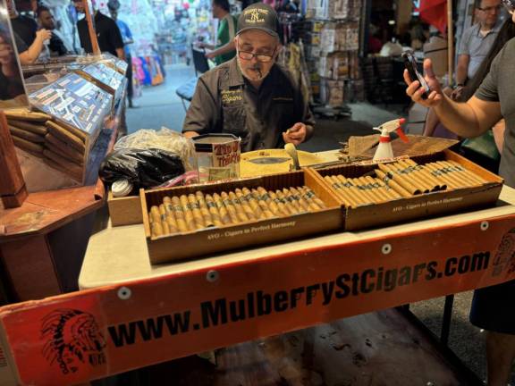 A master craftsman at Mulberry Street Cigars still hand rolls his cigars and was doing a brisk business selling $15 cigars.