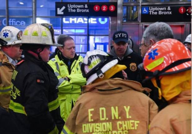 NYC Transit President Richard Davey (center, yellow hazard jacket) and NYPD chief of transit Michael Kempner (NYPD cap) at the scene of the 96th St. subway train collision on Jan. 4.