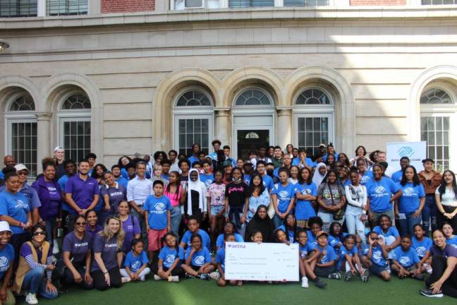 Members of the Boys &amp; Girls Club of Harlem smile with a $20,000 check from Aetna.