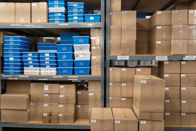 Several large and small cardboard boxes that contain cacao are neatly arranged throughout the factory.