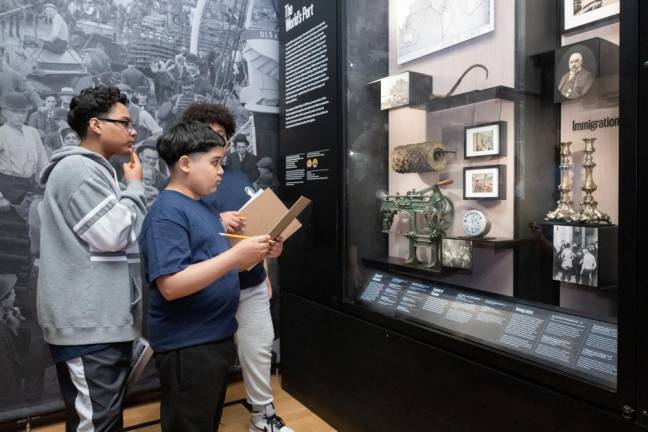 School kids taking notes on an exhibit about immigration at the Museum of the City of New York.