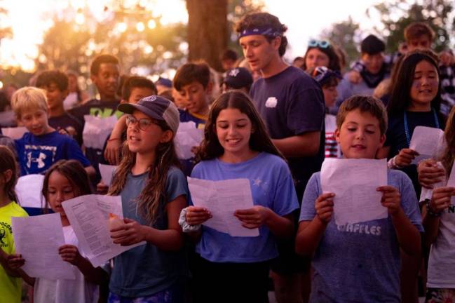 It is not all physical fitness at summer camp. Here young campers practice singing.