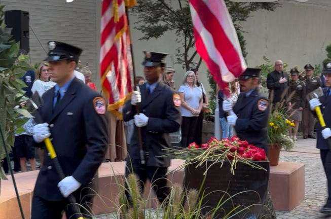 An FDNY color guard streams pass the fountain in the vest pocket memorial park on W. 48th St. just of Eighth Ave. where friends and family members left red roses in memory of the 15 firefighters who died on 9-11 at Battalion 9, Engine 54, Truck 4 firehouse. It was the house that suffered the most casualties on 9-11.