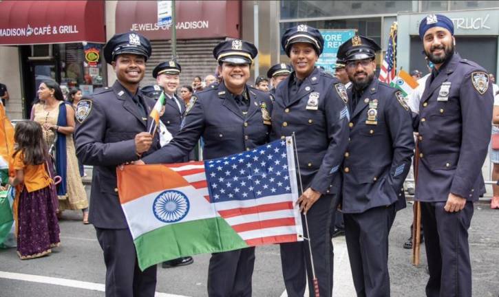 Smiling Desi Society officers with the hybrid Indian / American flag.