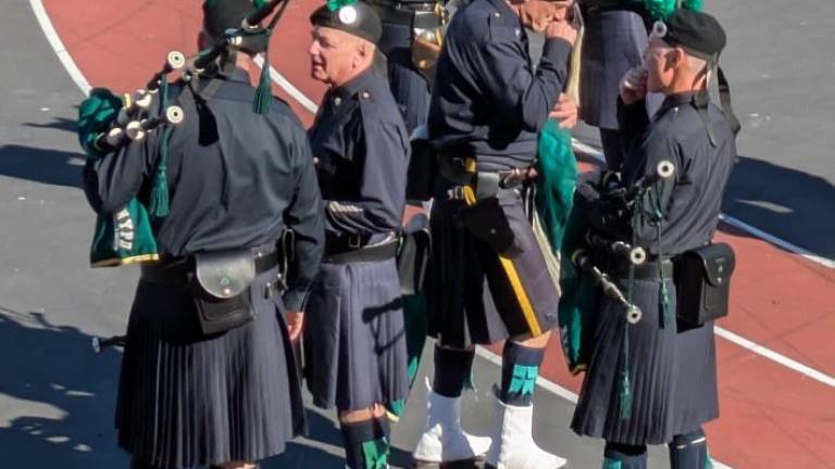 Pipers warming up and kids assembling in P.S. 42 playground.