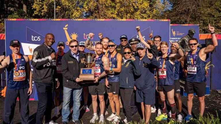 NYPD runners and brass with the Mayor’s Cup trophy. Recent combatants Tarik Shepherd (second from left) and Thomas Donlon (fourt from left) smile for the camera.