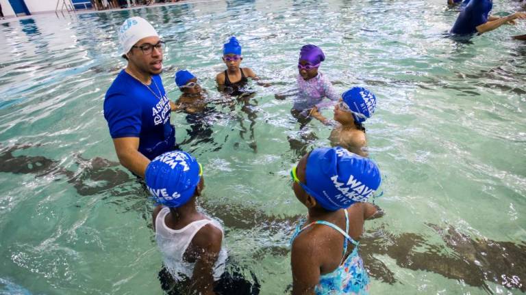 An instructor gives lessons to young swimmers following the ribbon cutting ceremony for the pool reopening at River East Elementary (2351 1st Avenue in Manhattan) on Friday, October 25, 2024. Up to 600 second graders will be eligible for free swimming lessons.