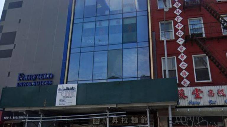 Glass facade building 107 East Broadway, near the corner of Pike Street c. 2022. On the ground floor is Lazhou Ramen. On the third floor, a secret People Republic of China police station. Today, the police station, and the scaffolding are gone. The noodles, happily, remain.